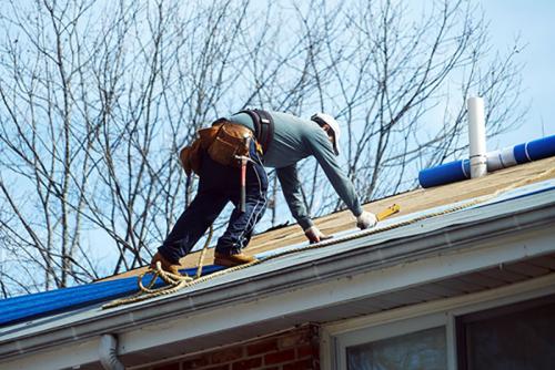 Handyman working on repairing the roof for design